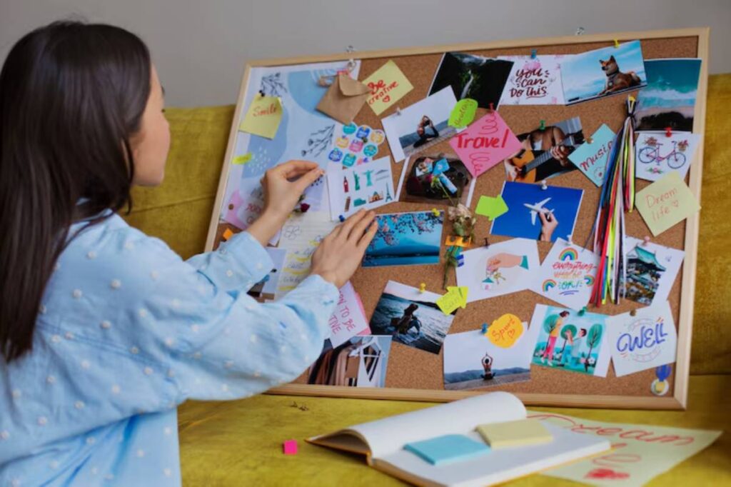 A person adds images and notes to a colorful corkboard filled with travel inspirations, motivational quotes, and memories.