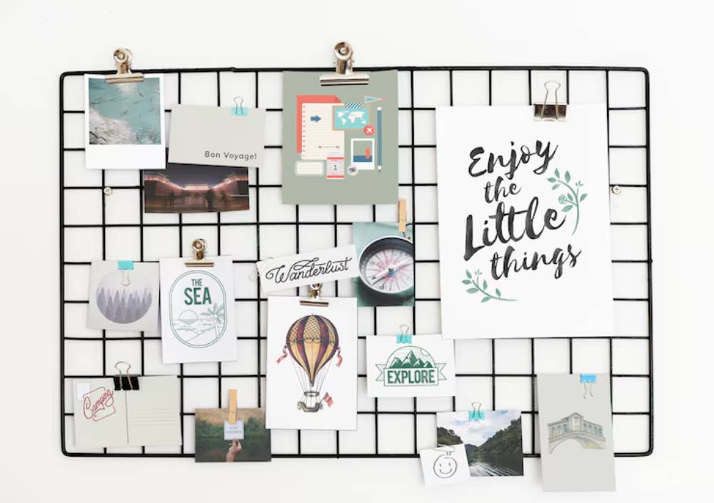 A wire grid displays various travel-themed photos and notes, including 'Enjoy the Little Things' and 'Wanderlust' messages.
