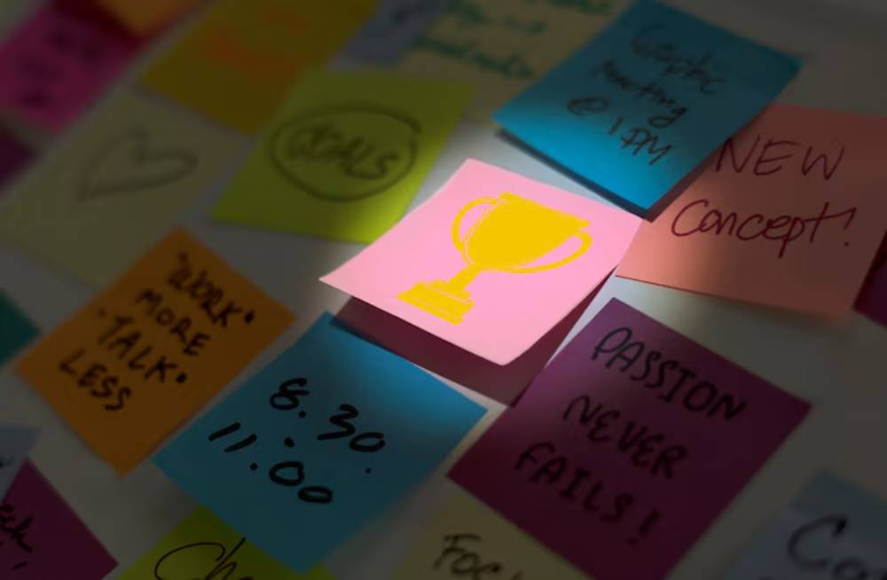 Colorful sticky notes on a wall, featuring motivational phrases and a highlighted note with a trophy symbol.